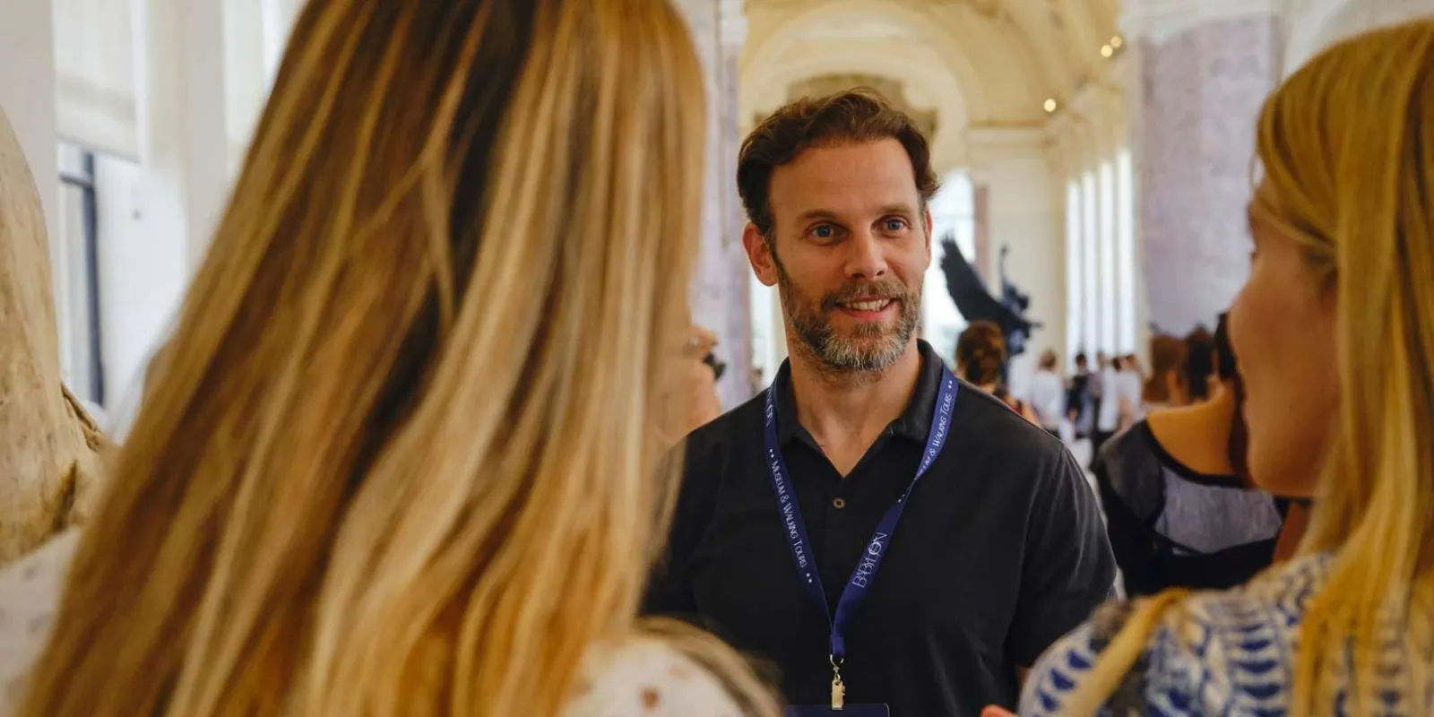 Guide speaking with visitors in a museum