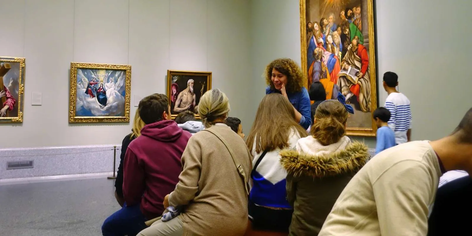 Guide discussing paintings with a small party